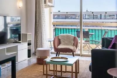 a living room with a chair and a television at Spacious 1-bedroom apartment in the heart of Cannes in Cannes