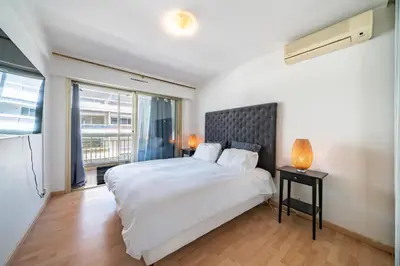a bedroom with a large white bed and a window at Spacious 1-bedroom apartment in the heart of Cannes in Cannes