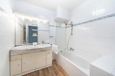 a white bathroom with a sink and a bath tub at Spacious 1-bedroom apartment in the heart of Cannes in Cannes
