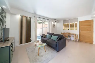 a living room with a couch and a table at Charmant appartement 2 pièces in Cannes