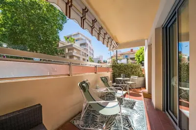 a balcony with chairs and tables on a building at Charmant appartement 2 pièces in Cannes