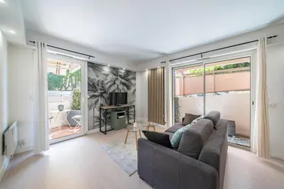 a living room with a couch and large windows at Charmant appartement 2 pièces in Cannes