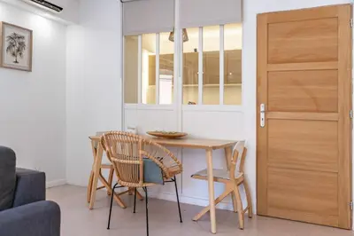 a kitchen with a table and chairs and a door at Charmant appartement 2 pièces in Cannes