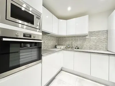 a kitchen with white cabinets and a microwave at Cannes one bedroom apartment - 8D1 in Cannes