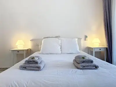 a bedroom with towels on a bed with two lamps at 47m2 - climatisation, carré d'or in Cannes