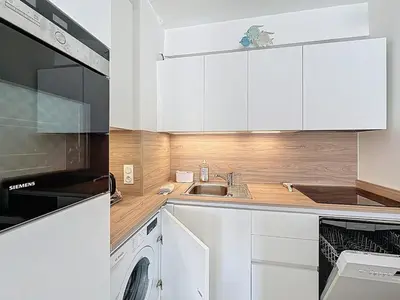a kitchen with white cabinets and a sink at 47m2 - climatisation, carré d'or in Cannes