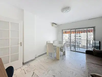 a white dining room with a table and chairs at 47m2 - climatisation, carré d'or in Cannes