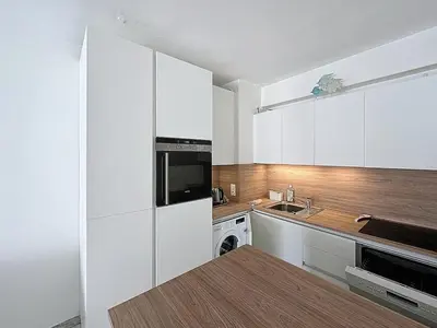 a white kitchen with a sink and a microwave at 47m2 - climatisation, carré d'or in Cannes