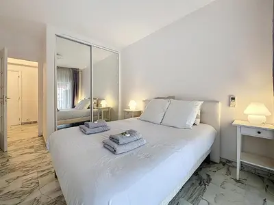 a bedroom with a large white bed with towels on it at 47m2 - climatisation, carré d'or in Cannes