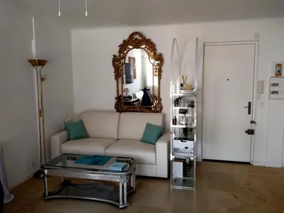 a bedroom with a white bed with a blue pillow at Cannes Centre Appartement Rénové avec Terrasse au Calme Plages & Croisette à Pied in Cannes