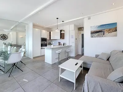 a living room and kitchen with a couch and a table at Vue mer 50 m plage et Croisette Cannes centre in Cannes