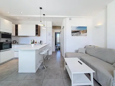 a white kitchen with white cabinets and a sink at Vue mer 50 m plage et Croisette Cannes centre in Cannes