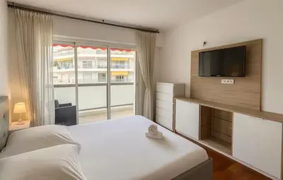 a bedroom with a bed and a flat screen tv at Appartement rue D'antibes in Cannes