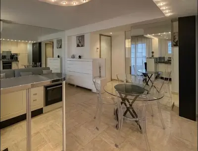 a kitchen with a glass table and chairs and a kitchen with a counter at Appartement rue D'antibes in Cannes