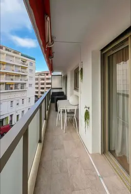 a balcony of a building with a table and chairs at Appartement rue D'antibes in Cannes