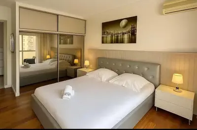a bedroom with a large white bed and two beds at Appartement rue D'antibes in Cannes