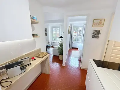 a kitchen with white cabinets and a red tile floor at Cosy & modern 1 Bedroom Forville old town 207 in Cannes