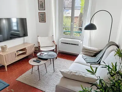 a living room with a couch and a tv at Cosy & modern 1 Bedroom Forville old town 207 in Cannes