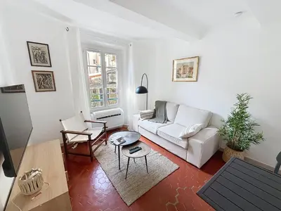 a living room with a white couch and a table at Cosy & modern 1 Bedroom Forville old town 207 in Cannes