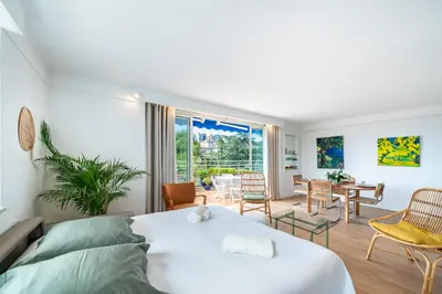 a bedroom with a bed and a living room at 2 pièces proche centre Cannes - Vue mer panoramique - Toit terrasse in Cannes