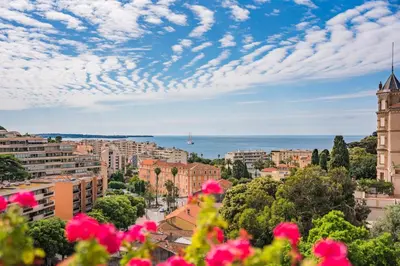 a view of a city with pink flowers at 2 pièces proche centre Cannes - Vue mer panoramique - Toit terrasse in Cannes