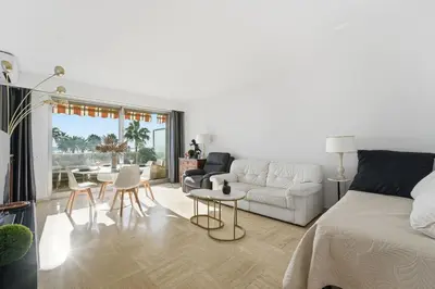 a living room with a bed and a table and chairs at La Rose des Vents - Cannes in Cannes