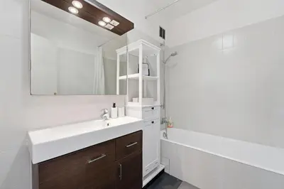 a white bathroom with a sink and a mirror at La Rose des Vents - Cannes in Cannes