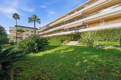 an apartment building with a lawn in front of it at La Rose des Vents - Cannes in Cannes