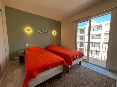 a bedroom with a bed with red sheets and a window at Riva in Cannes