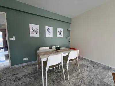 a dining room with a table and white chairs at Riva in Cannes