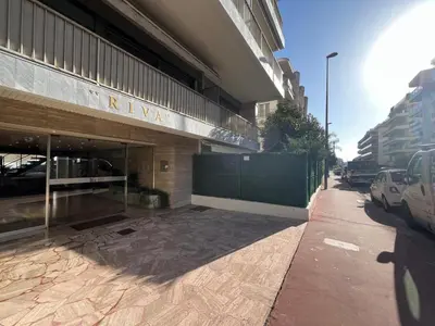 a building on a sidewalk next to a street at Riva in Cannes