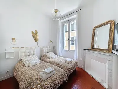 a bedroom with two beds and a mirror at 42 m2 - Close to Palais des Festivals and beaches in Cannes