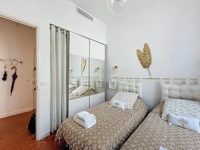 a bedroom with two beds and a mirror at 42 m2 - Close to Palais des Festivals and beaches in Cannes