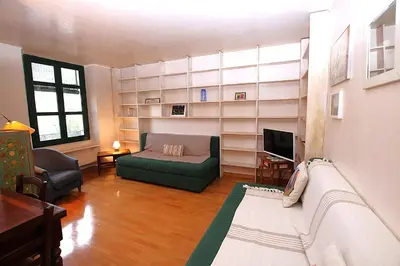 a living room with a couch and a tv at Cannes Central Hub - Walk to Palais & Beach in Cannes