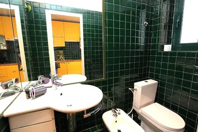 a green tiled bathroom with a sink and a toilet at Cannes Central Hub - Walk to Palais & Beach in Cannes