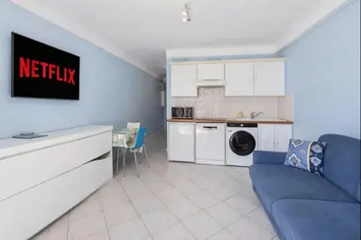 a living room with a blue couch and a kitchen at Carlton in Cannes