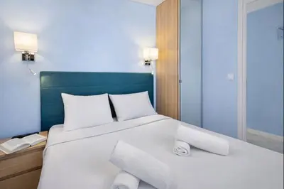 a bed with white pillows and a blue head board at Carlton in Cannes