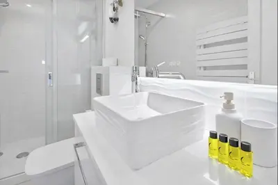 a white bathroom with a sink and a shower at Carlton in Cannes