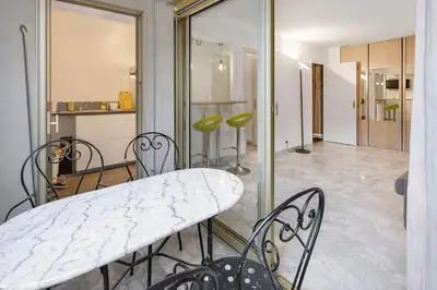 a dining room with a marble table and chairs at Branly in Cannes