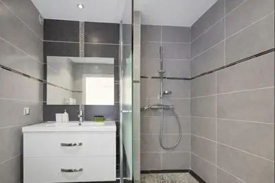 a bathroom with a shower and a sink and a mirror at Branly in Cannes