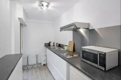 a kitchen with a sink and a microwave on a counter at Branly in Cannes