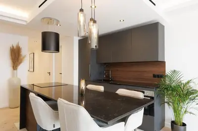 a dining room with a black table and white chairs at Quartier Marriott - Superbe 3 pieces in Cannes