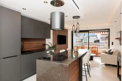 a kitchen with a counter top and a living room at Quartier Marriott - Superbe 3 pieces in Cannes