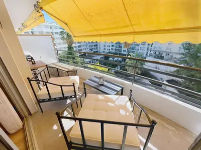 a balcony with tables and chairs and a large window at Beautifull studio with balcony Rouaze Miramar 120 in Cannes