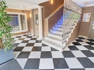 a lobby with a checkered floor and stairs at Beautifull studio with balcony Rouaze Miramar 120 in Cannes