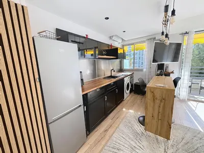 a kitchen with a refrigerator and a table in it at Beautifull studio with balcony Rouaze Miramar 120 in Cannes