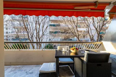 a table on a balcony with a view of a building at 1-Br Near the Croisette and City Centre in Cannes