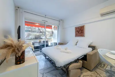 a bedroom with a bed and a large window at 1-Br Near the Croisette and City Centre in Cannes