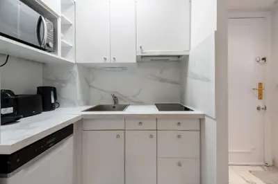 a white kitchen with a sink and a microwave at 1-Br Near the Croisette and City Centre in Cannes