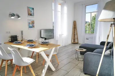 a living room with a table and a blue couch at 2 Bedrooms Apartment-Cannes Center Suquet-2mins to Beach & 10mins to Palais-AirConditioning & FiberWifi in Cannes